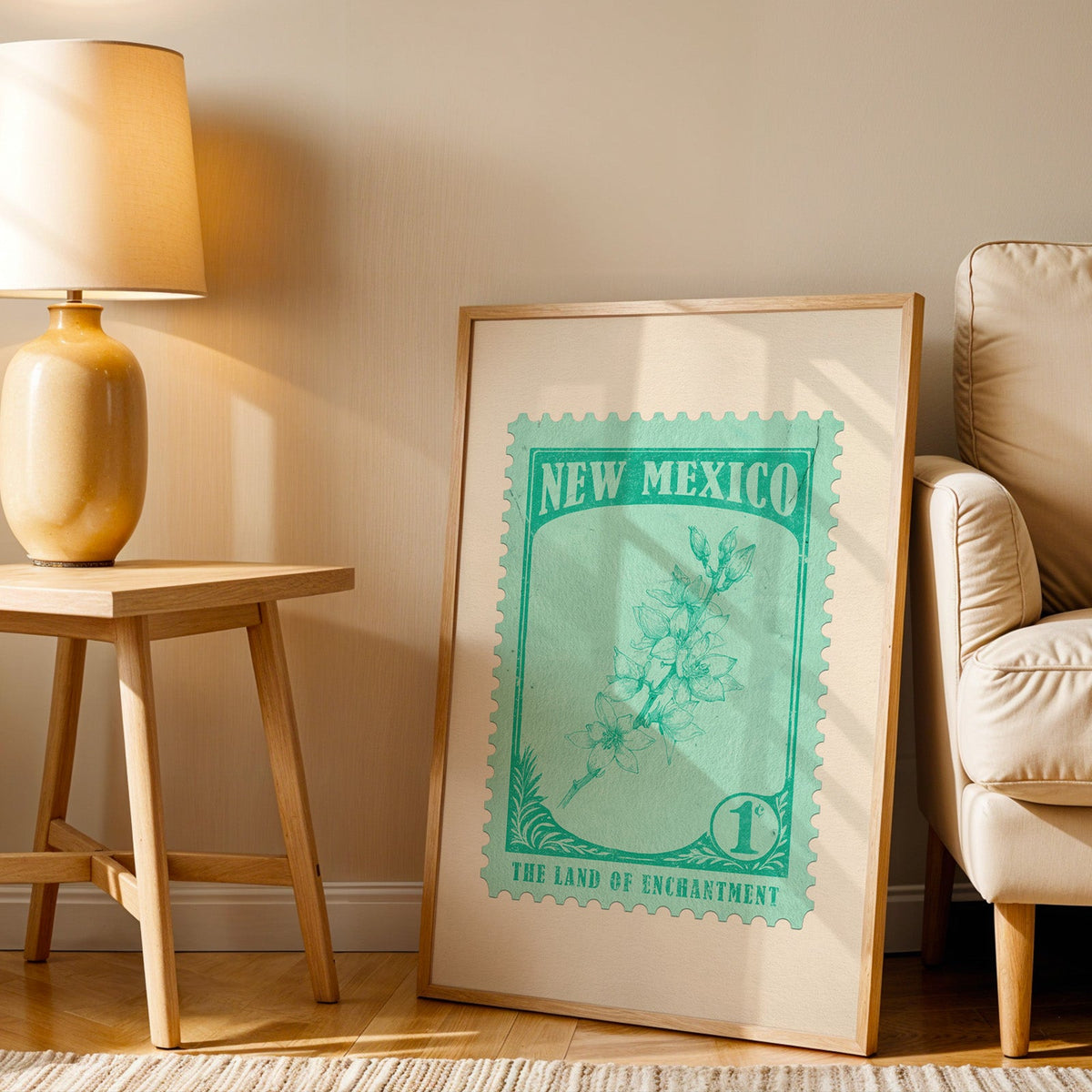 New Mexico stamp print in a wood frame resting on the floor beside a beige armchair and a yellow lamp