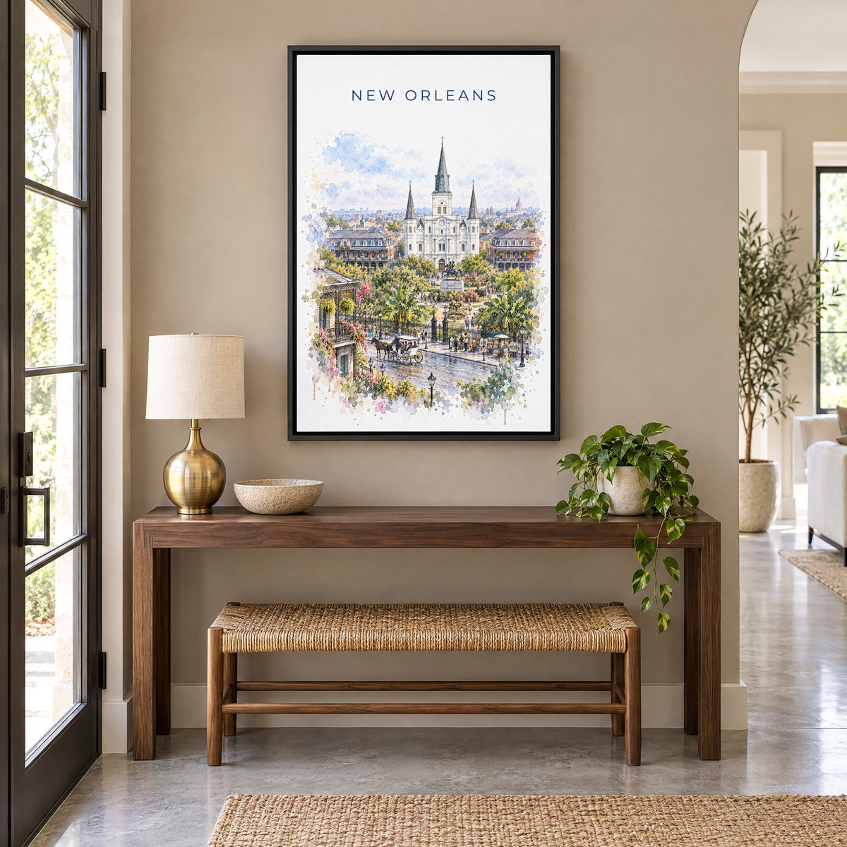 New Orleans watercolor print as a black floater canvas above a walnut console and woven bench in an entryway
