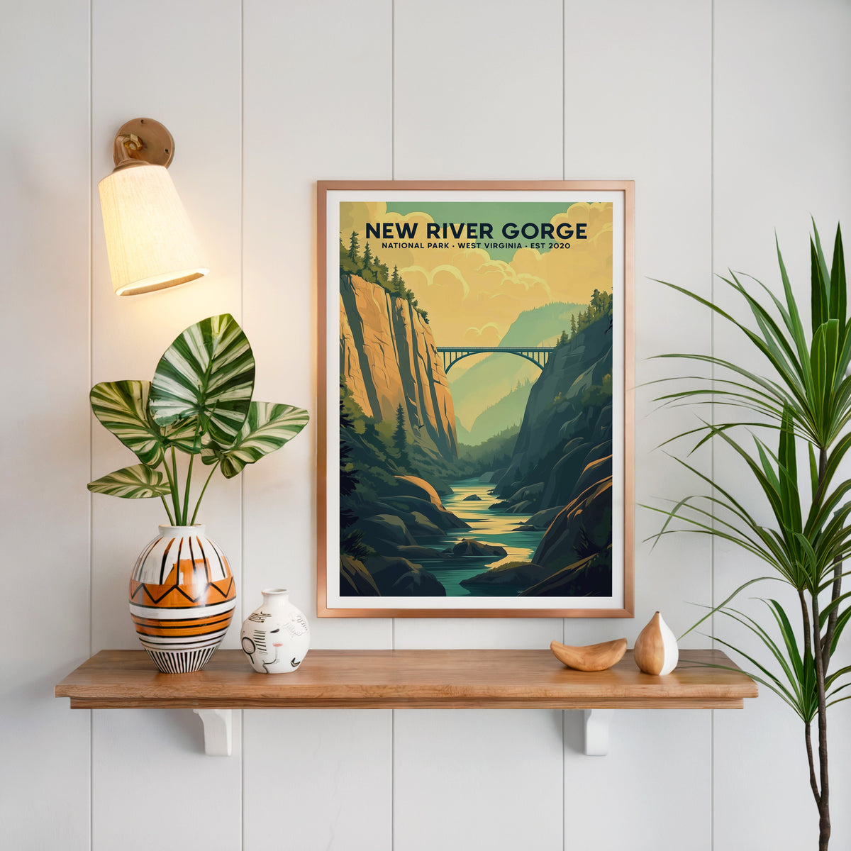 New River Gorge National Park print in a copper frame above an oak shelf on white shiplap with a brass sconce