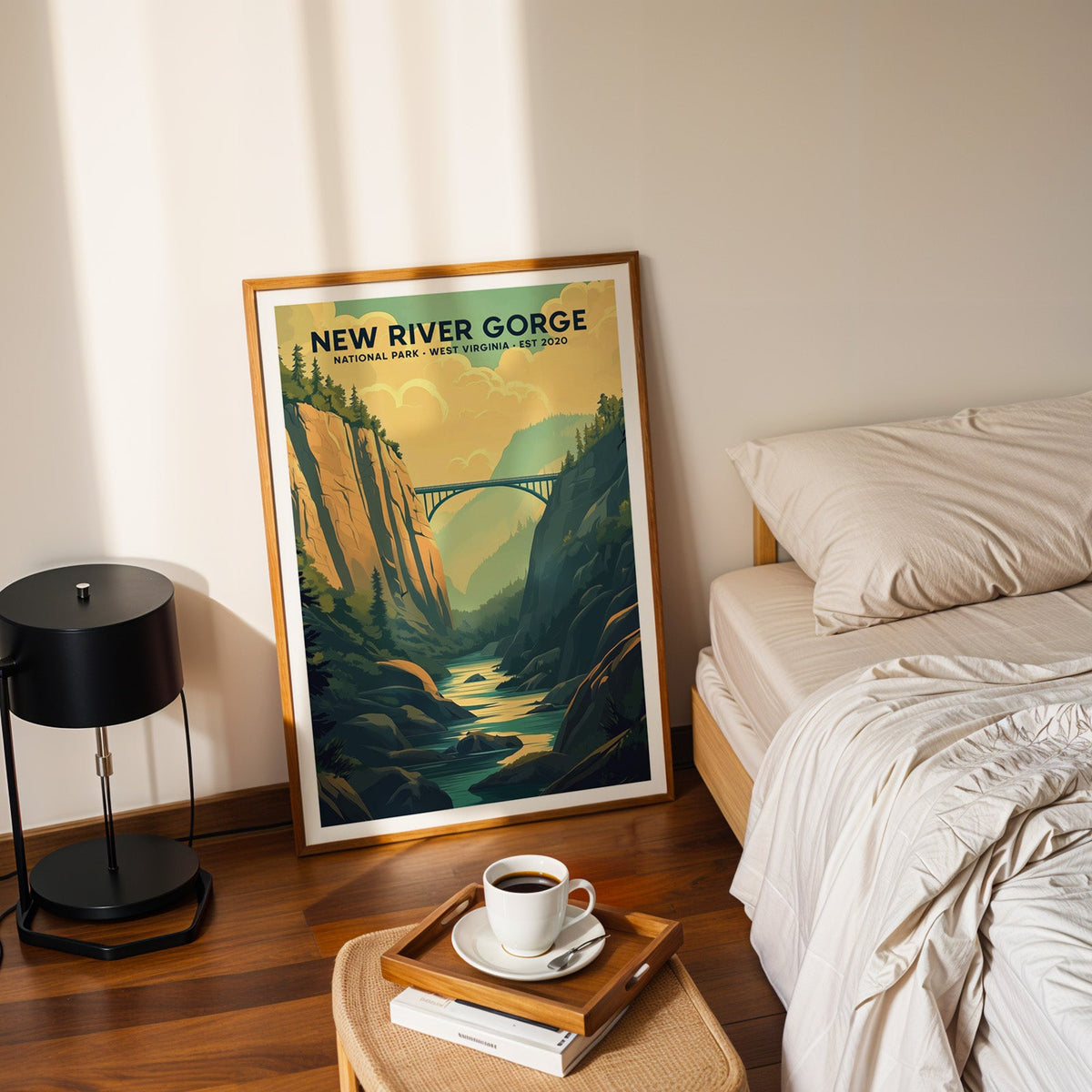New River Gorge National Park print in an oak frame leaning on a bedroom floor beside the bed and a coffee tray