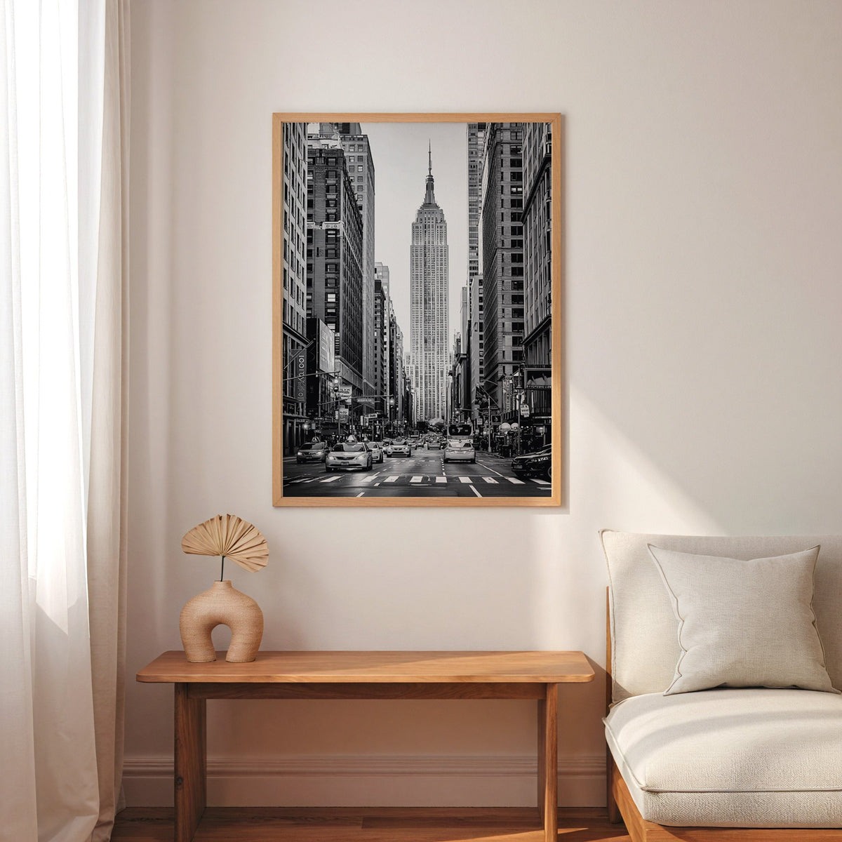 Empire State Building avenue with taxis print in an oak frame above a narrow console with an arched vase