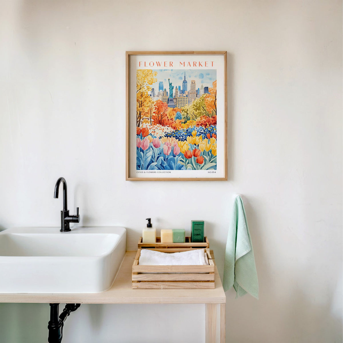 New York flower market print in an oak frame above a white bathroom sink with folded towels