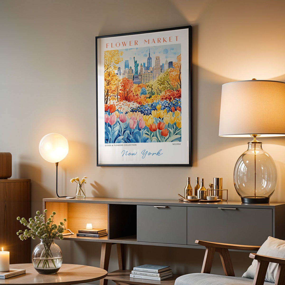 New York flower market print in a black frame above a grey media console with a glass table lamp
