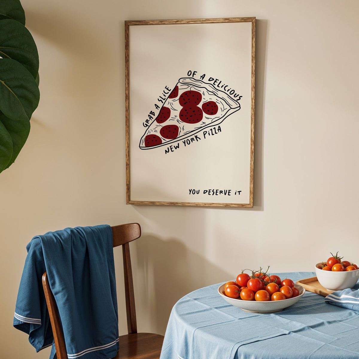 New York pizza slice print in an oak frame above a blue linen table with ripe tomatoes