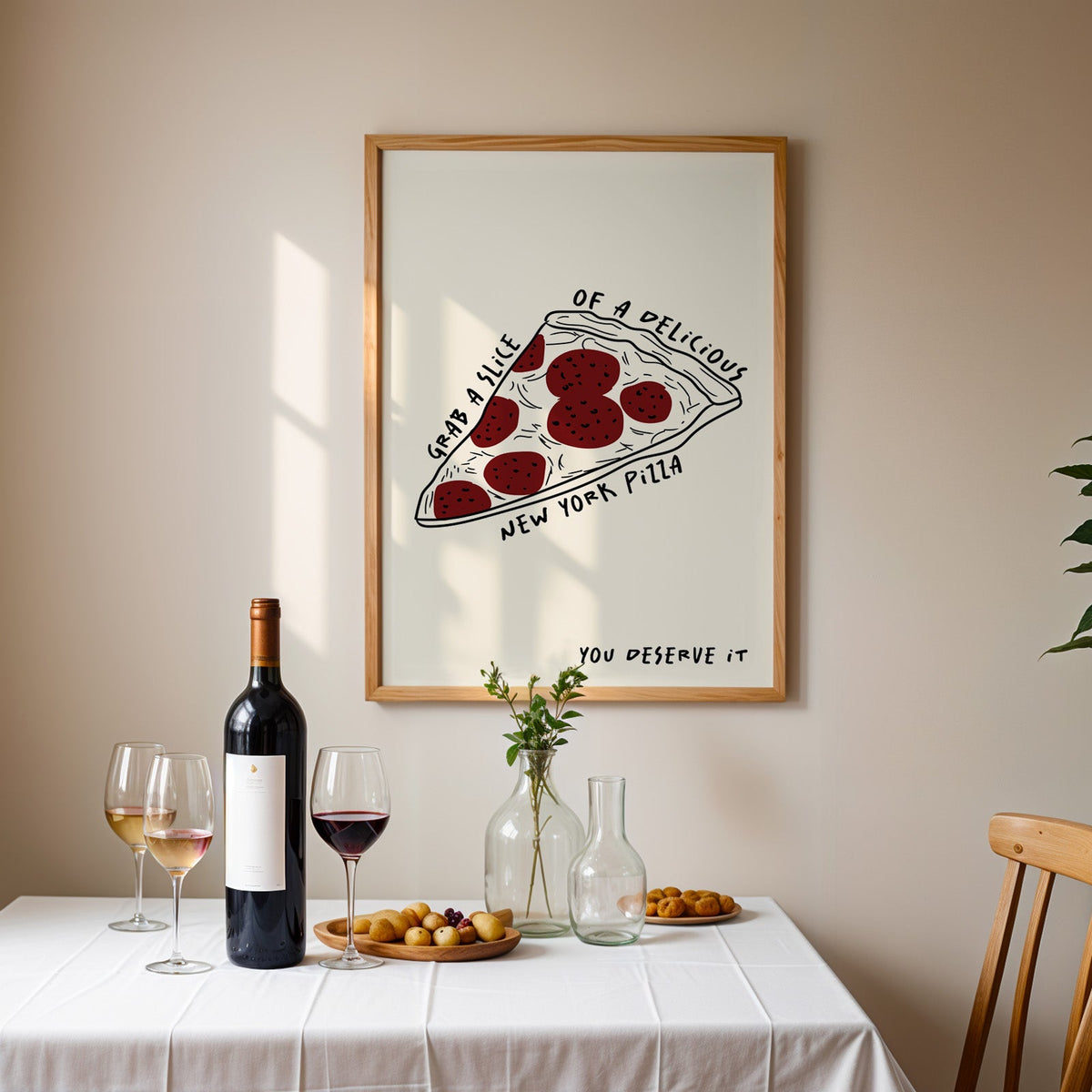 New York pizza slice print in an oak frame above a table laid with red wine and glasses