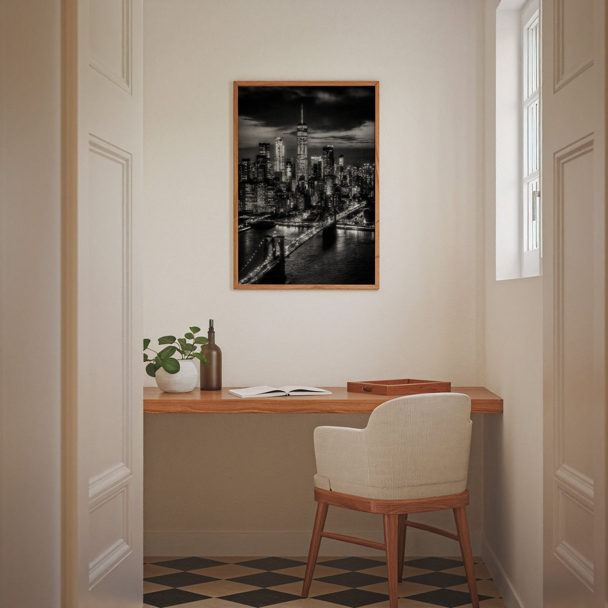 New York skyline at night with Brooklyn Bridge print in an oak frame above a home office desk nook