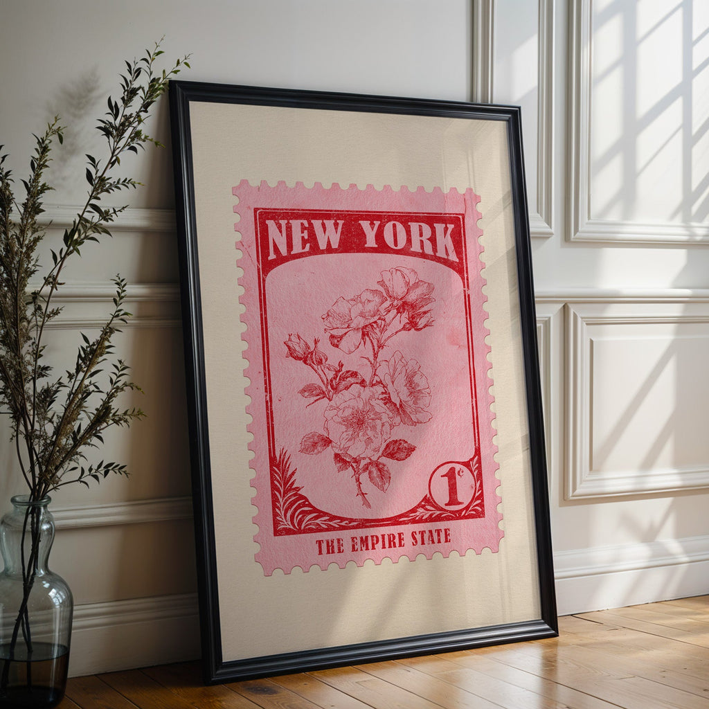 New York state flower print in a black frame leaning against a white panelled wall beside olive branches
