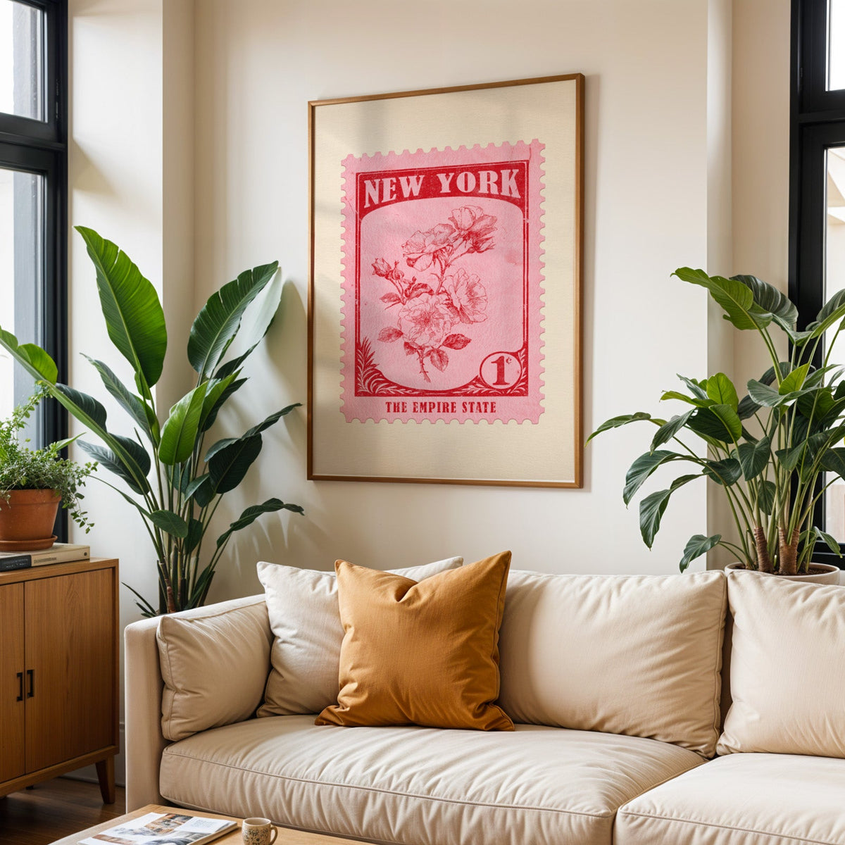 New York state flower print framed above a cream sofa with an ochre cushion and large plants either side