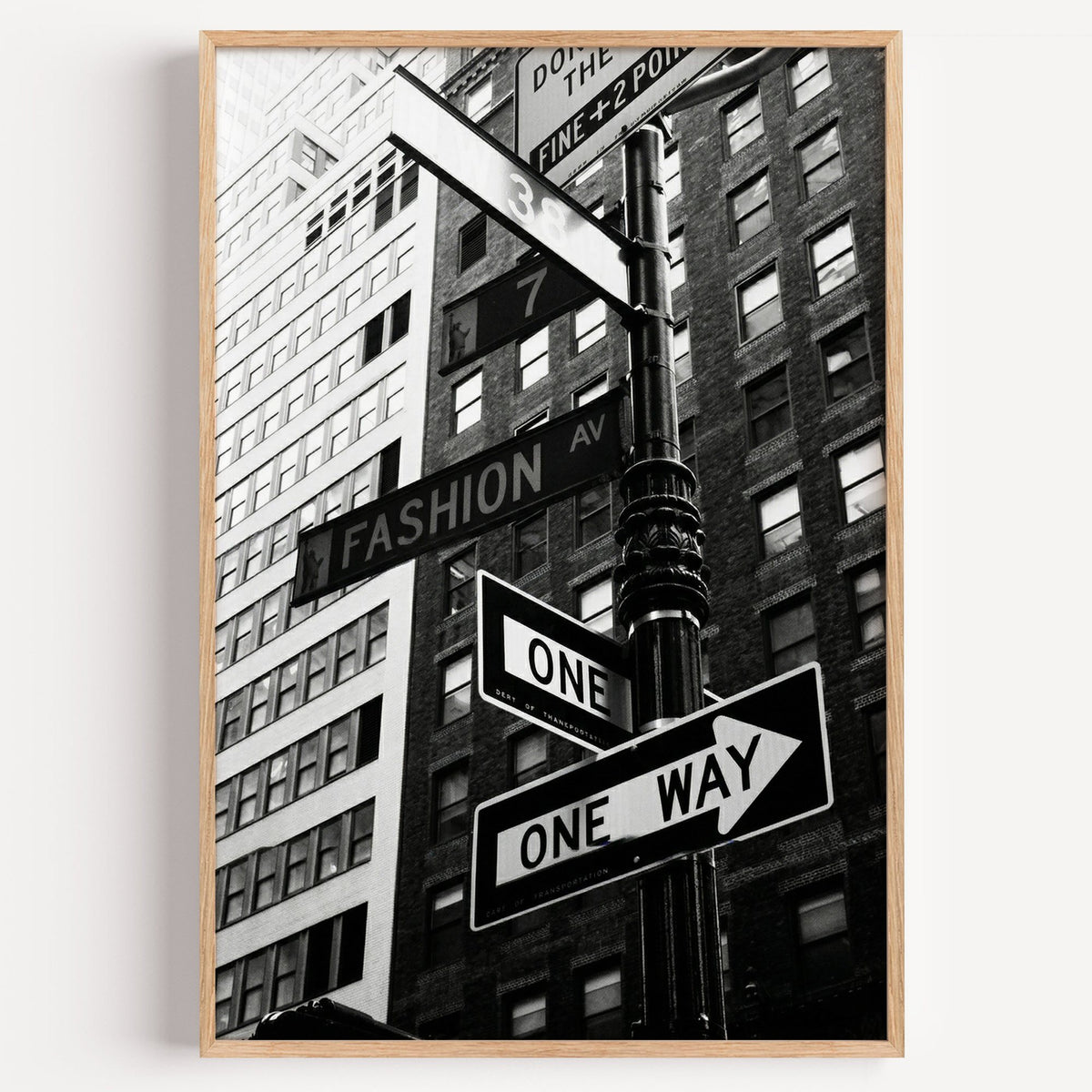 New York street sign pole with one way signs print in a light oak frame on a plain white wall