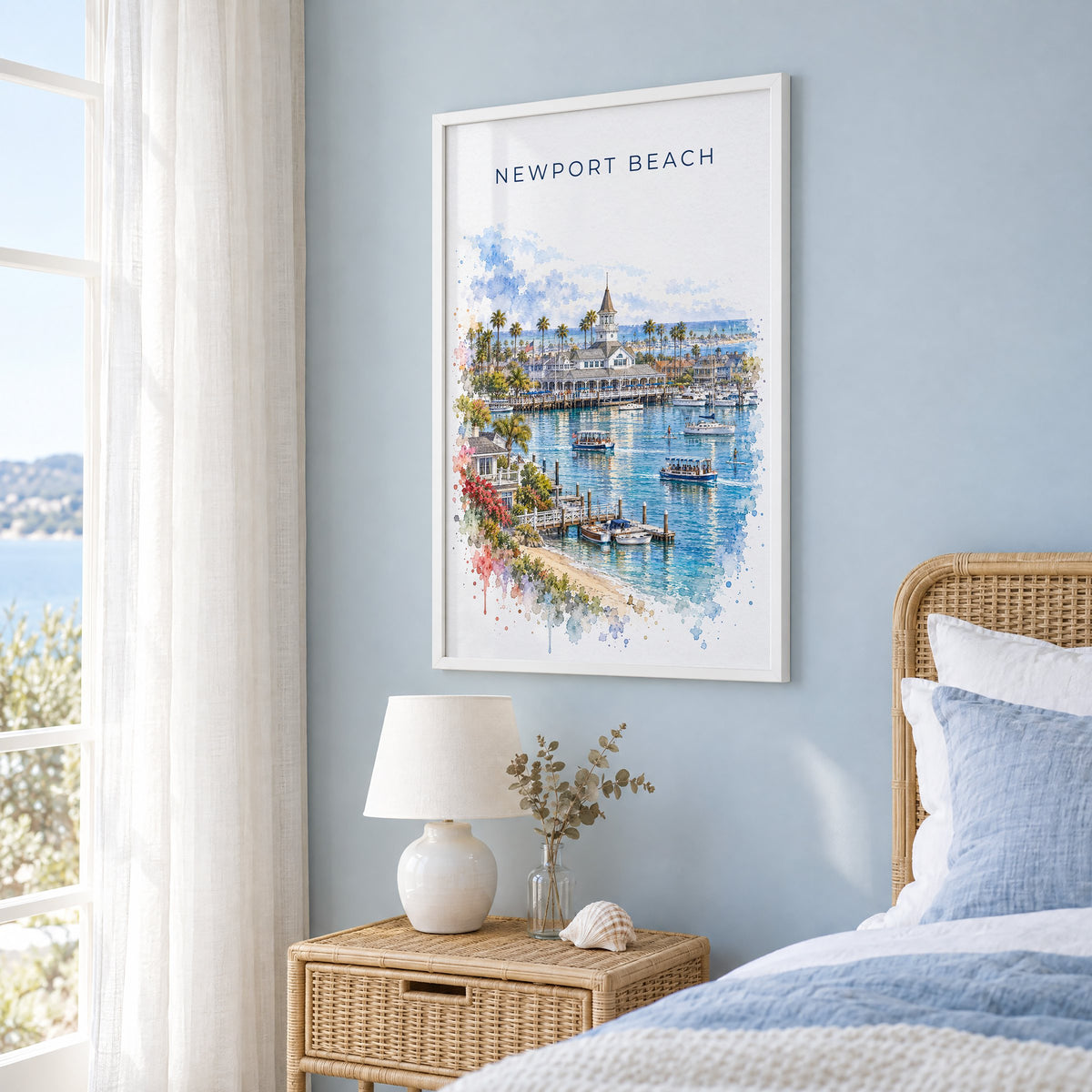 Newport Beach watercolor print in a white frame on a pale blue wall beside a rattan bed in a coastal bedroom