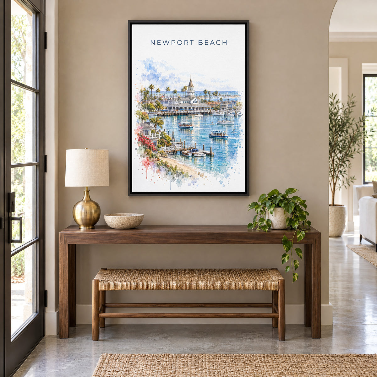 Newport Beach watercolor print as a black floater canvas above a walnut console and woven bench in an entryway