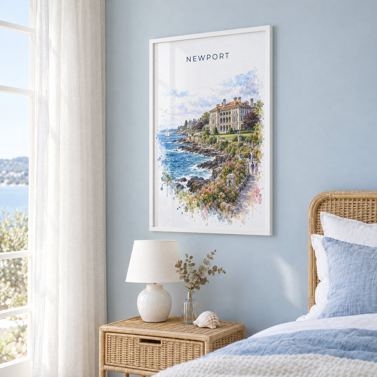 Newport, Rhode Island watercolor print in a white frame on a pale blue wall beside a rattan bed in a coastal bedroom