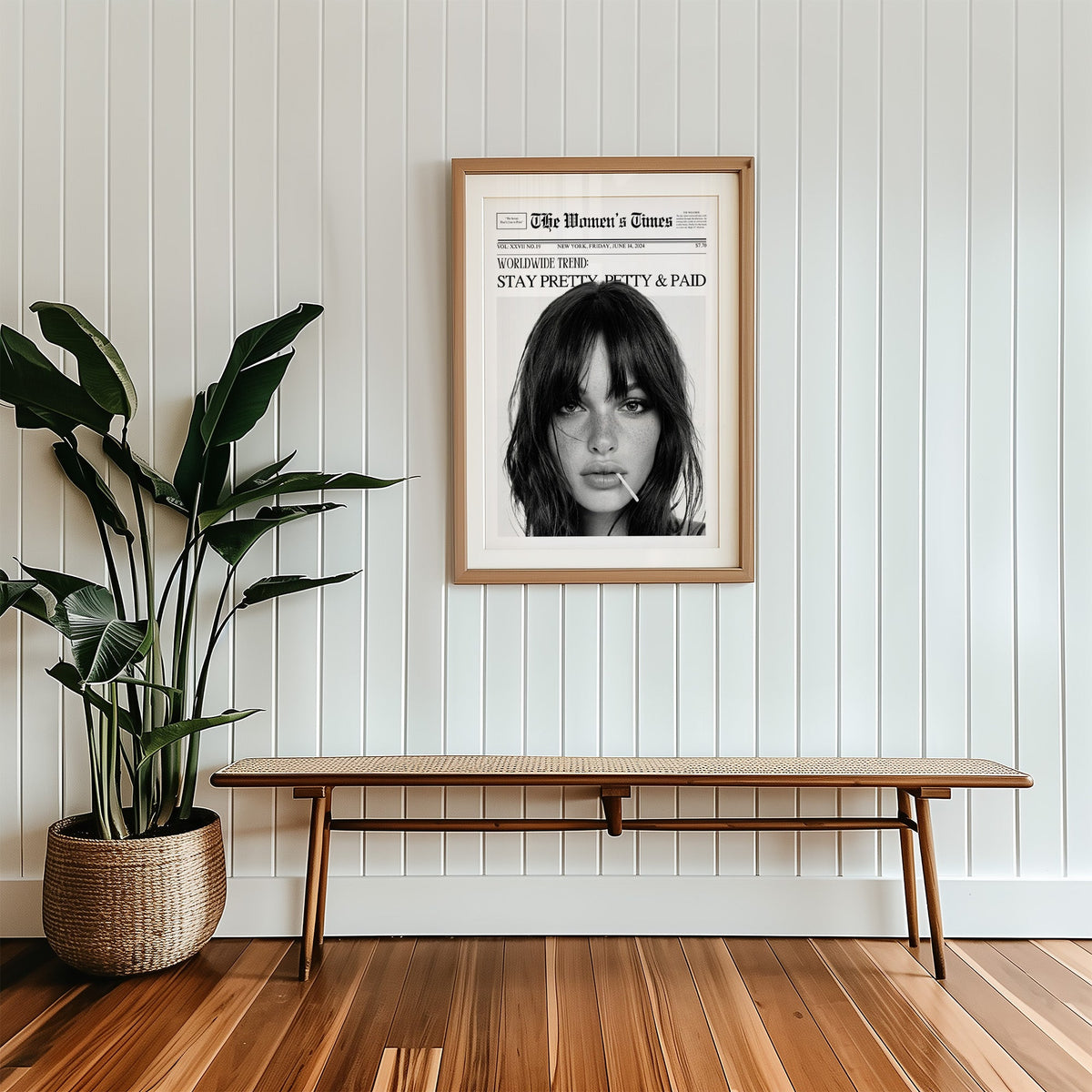 Mock front page with close-up of woman and lollipop print in a wood frame with a white mat above a cane bench