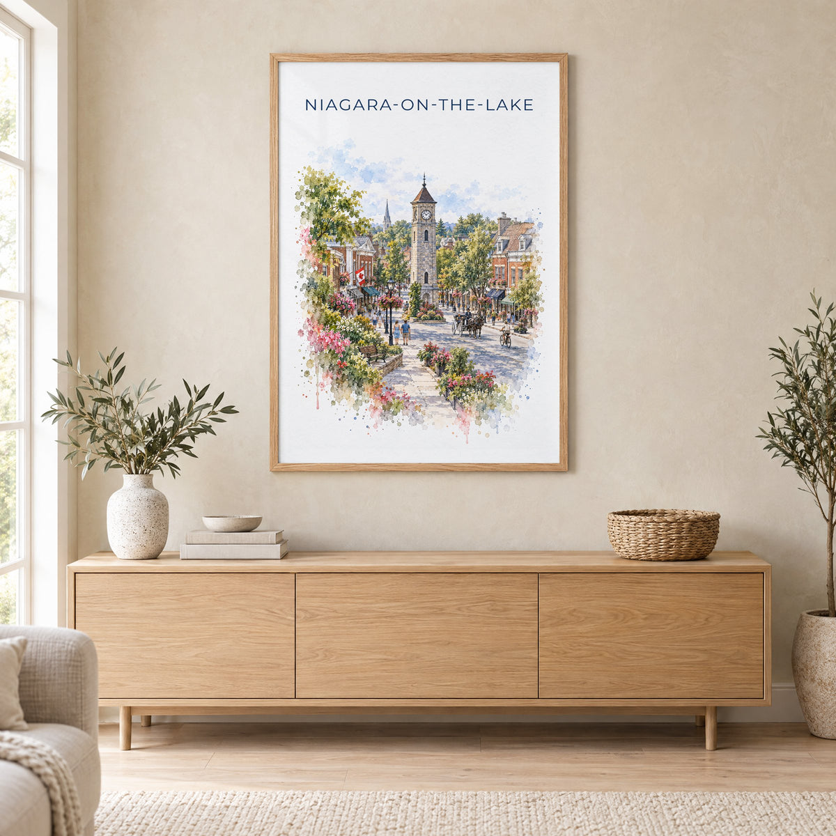 Niagara-on-the-Lake watercolor print in an oak frame above a light wood sideboard in a Scandinavian living room