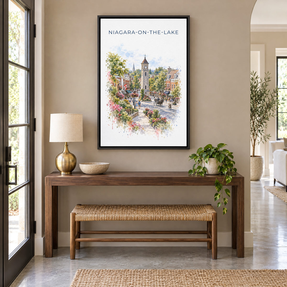 Niagara-on-the-Lake watercolor print as a black floater canvas above a walnut console and woven bench in an entryway