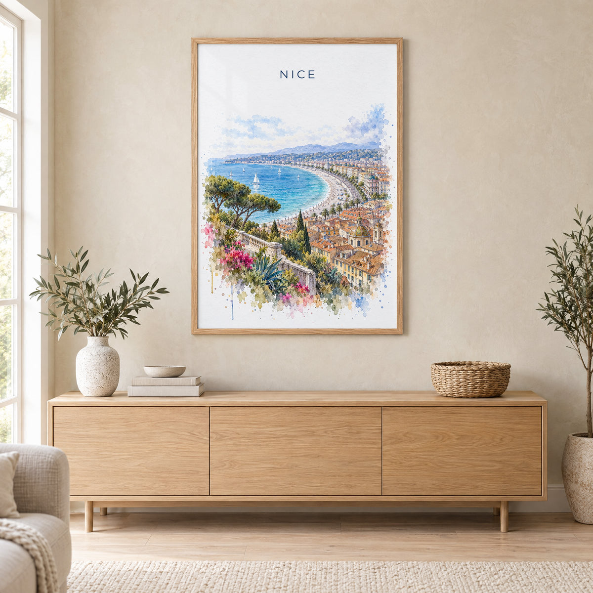 Nice, France watercolor print in an oak frame above a light wood sideboard in a Scandinavian living room