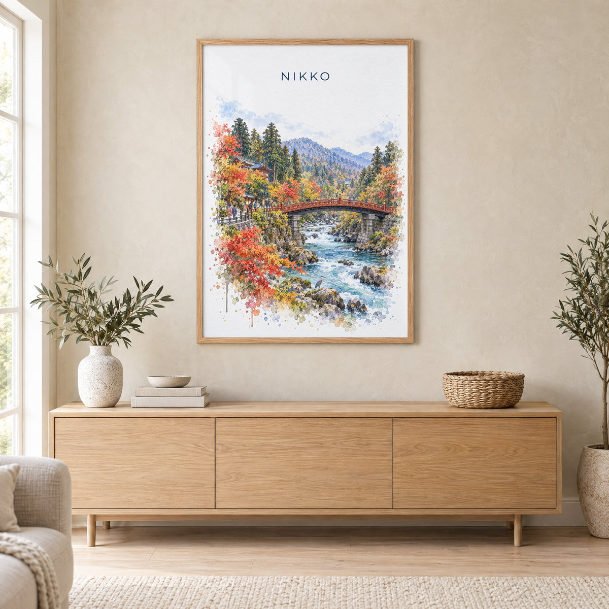 Nikko watercolor print in an oak frame above a light wood sideboard in a Scandinavian living room