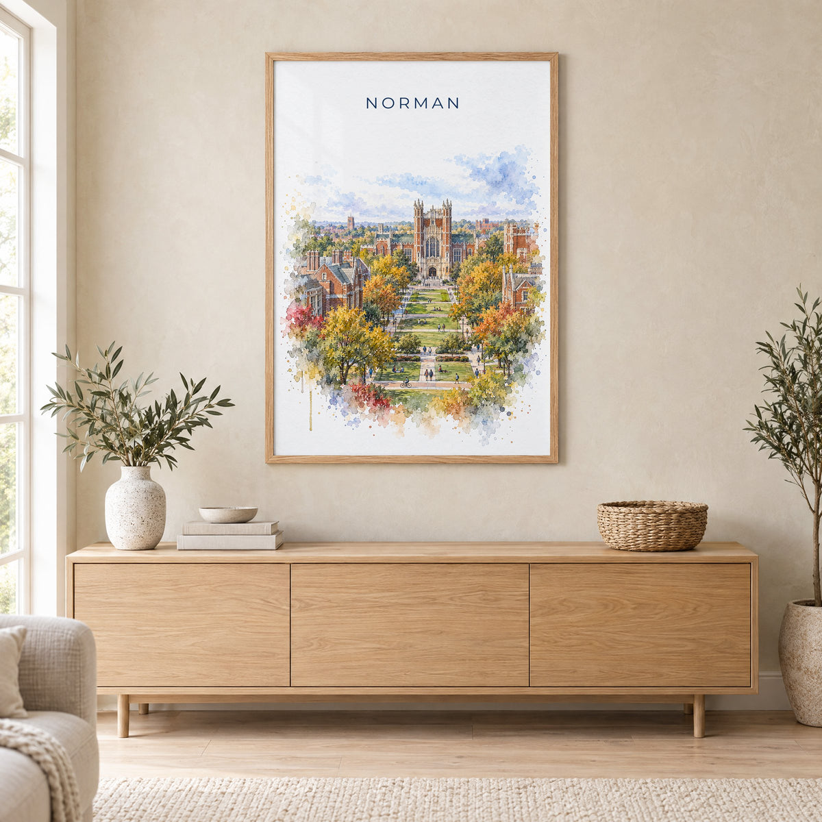 Norman, Oklahoma watercolor print in an oak frame above a light wood sideboard in a Scandinavian living room