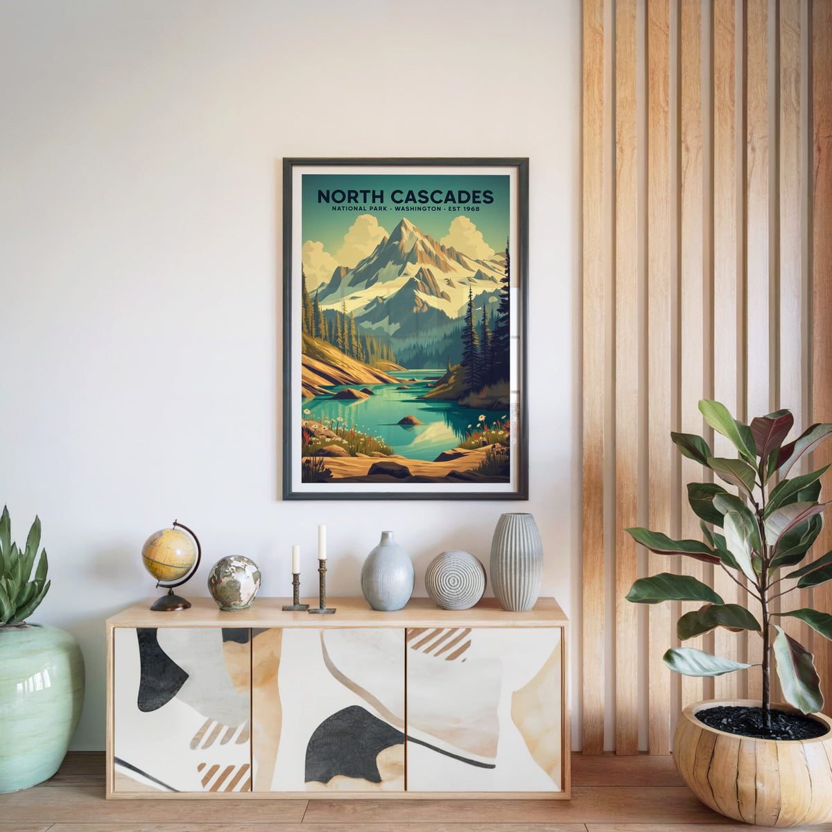 North Cascades National Park print in a black frame above a light wood sideboard with a globe and ceramic vases