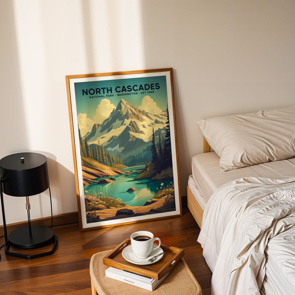 North Cascades National Park print in an oak frame leaning on a bedroom floor beside the bed and a coffee tray