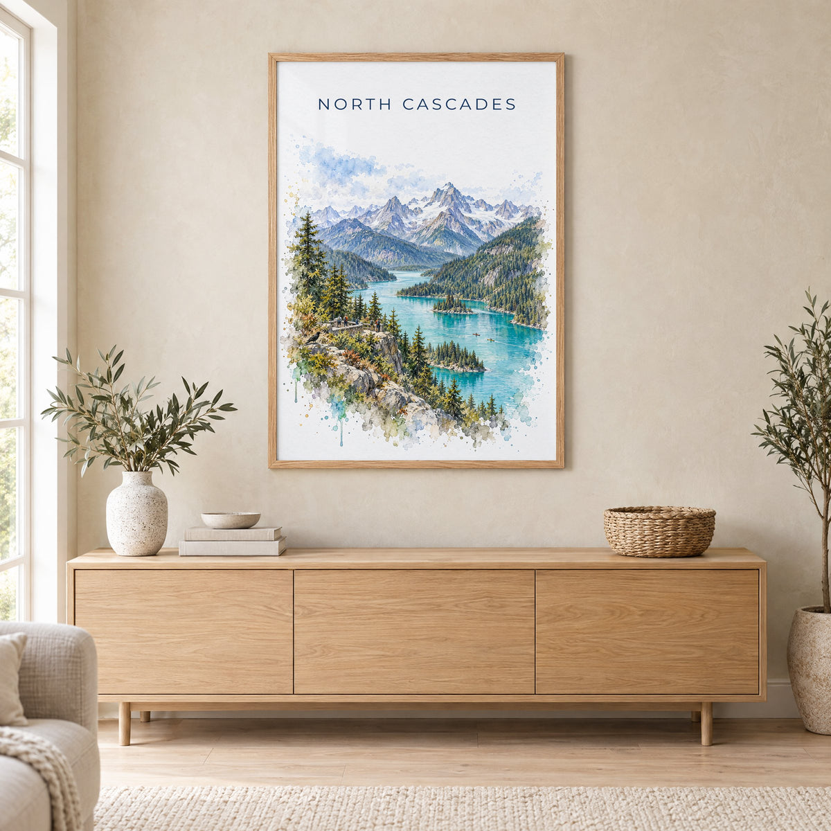 North Cascades National Park watercolor print in an oak frame above a light wood sideboard in a Scandinavian living room