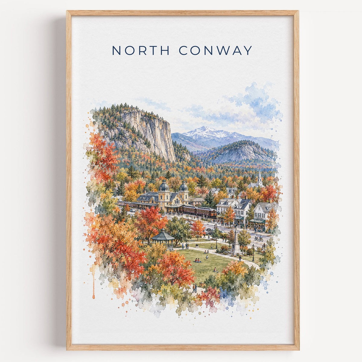 North Conway, New Hampshire watercolor print in a light oak frame on a plain white wall