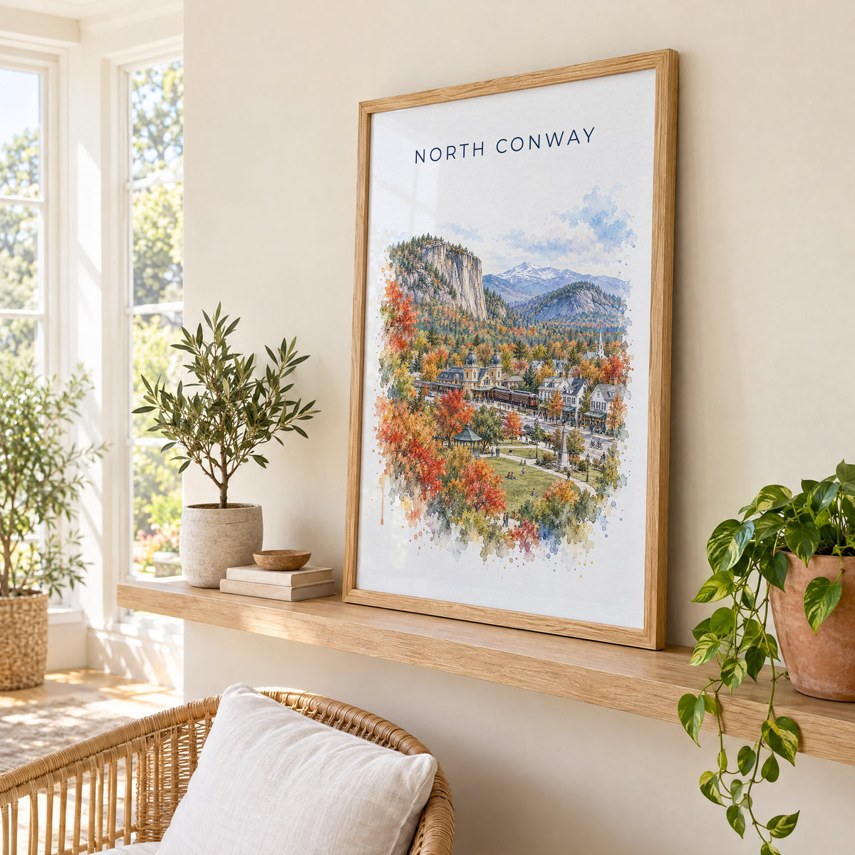 North Conway, New Hampshire watercolor print in an oak frame on a picture ledge in a sunlit sunroom