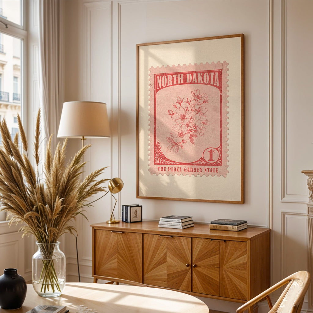 North Dakota stamp print framed above a wooden sideboard, pampas grass in a glass vase and a floor lamp