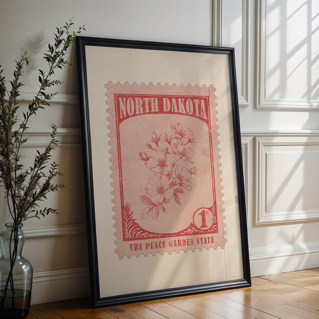 North Dakota state flower print in a black frame leaning against a white panelled wall beside olive branches