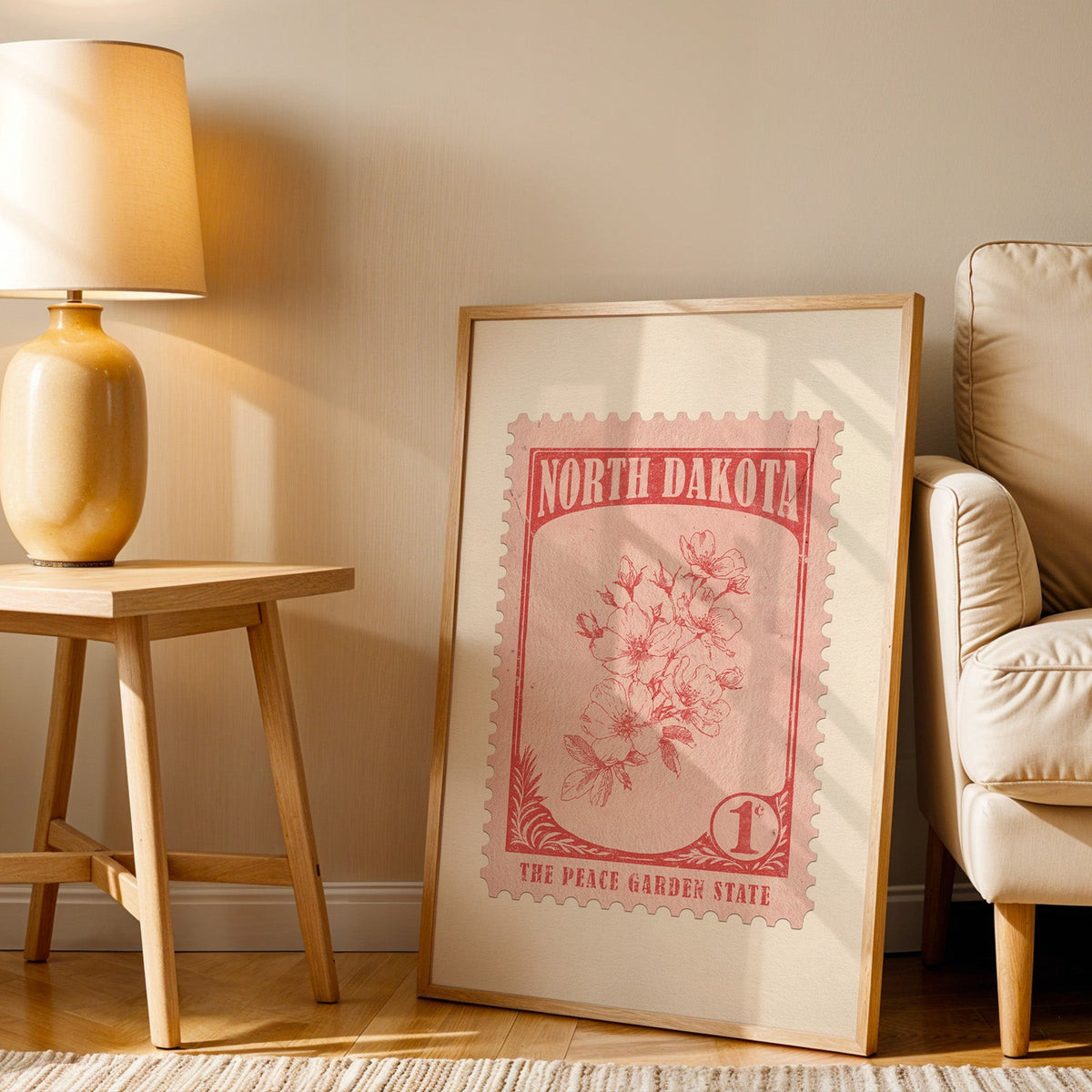 North Dakota stamp print in a wood frame resting on the floor beside a beige armchair and a yellow lamp