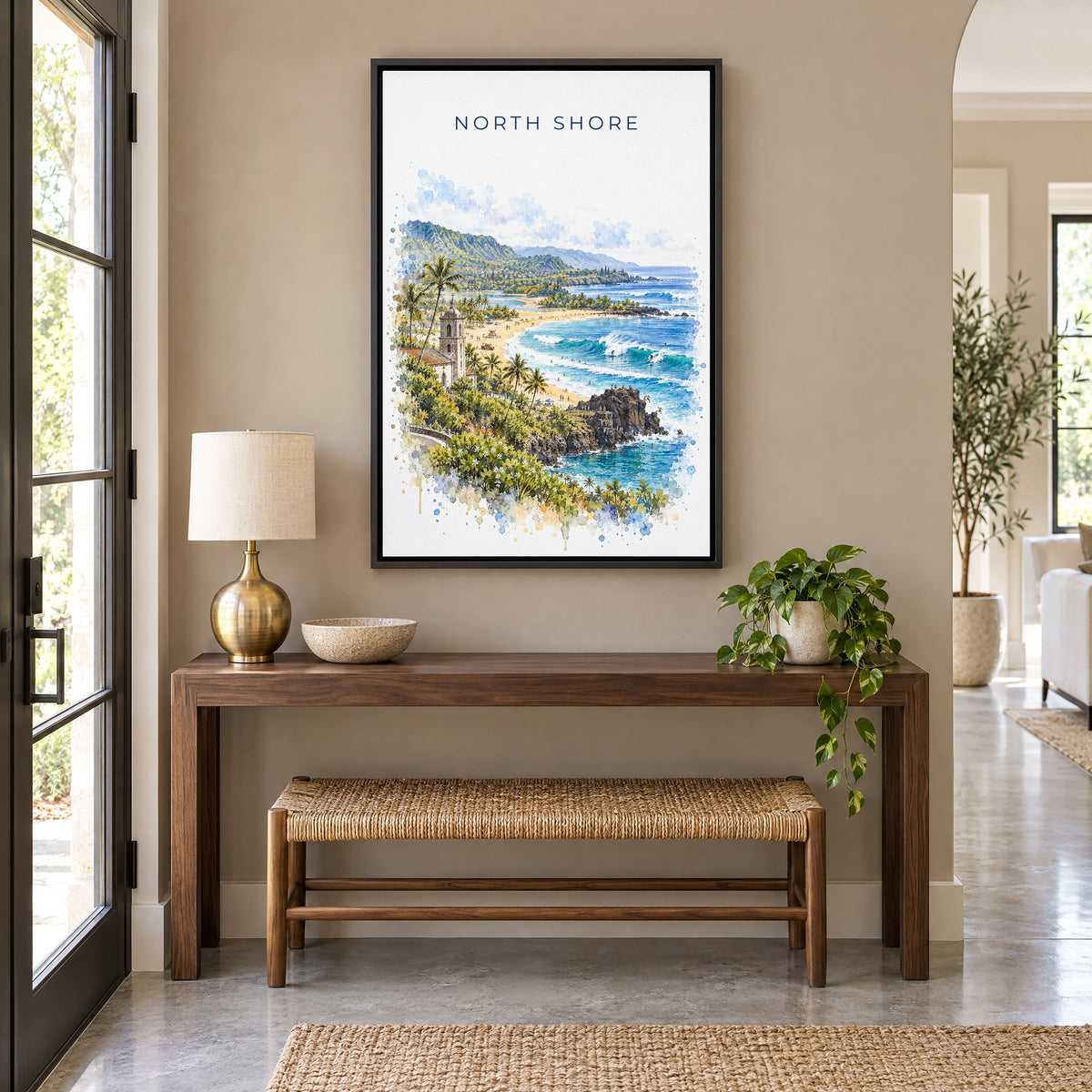 North Shore, Oahu watercolor print as a black floater canvas above a walnut console and woven bench in an entryway