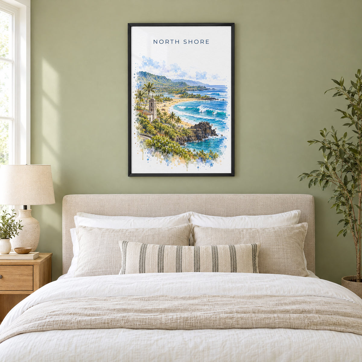 North Shore, Oahu watercolor print in a black frame above an upholstered headboard in a sage green bedroom
