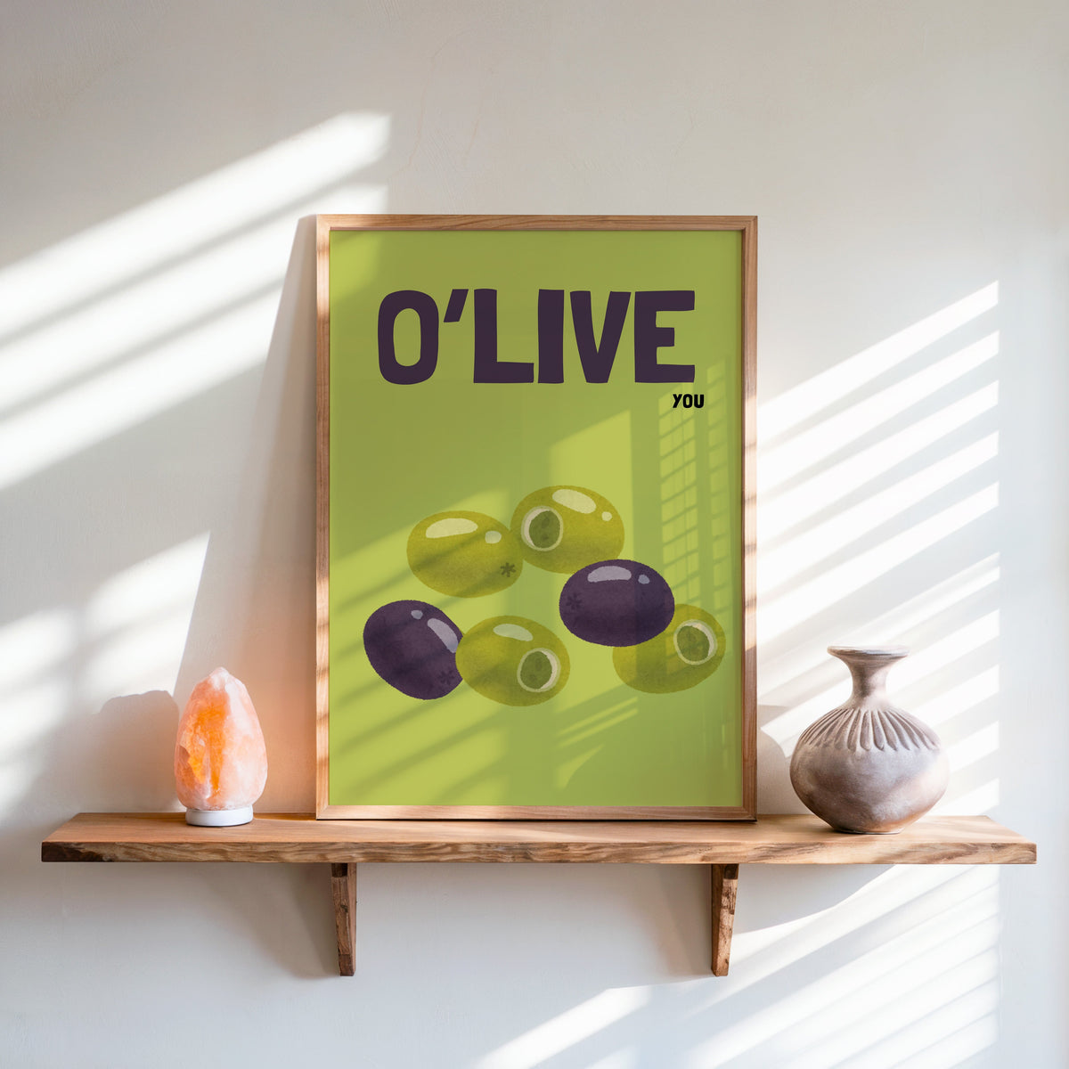 O Live You olives print in an oak frame on a live-edge shelf beside a salt lamp