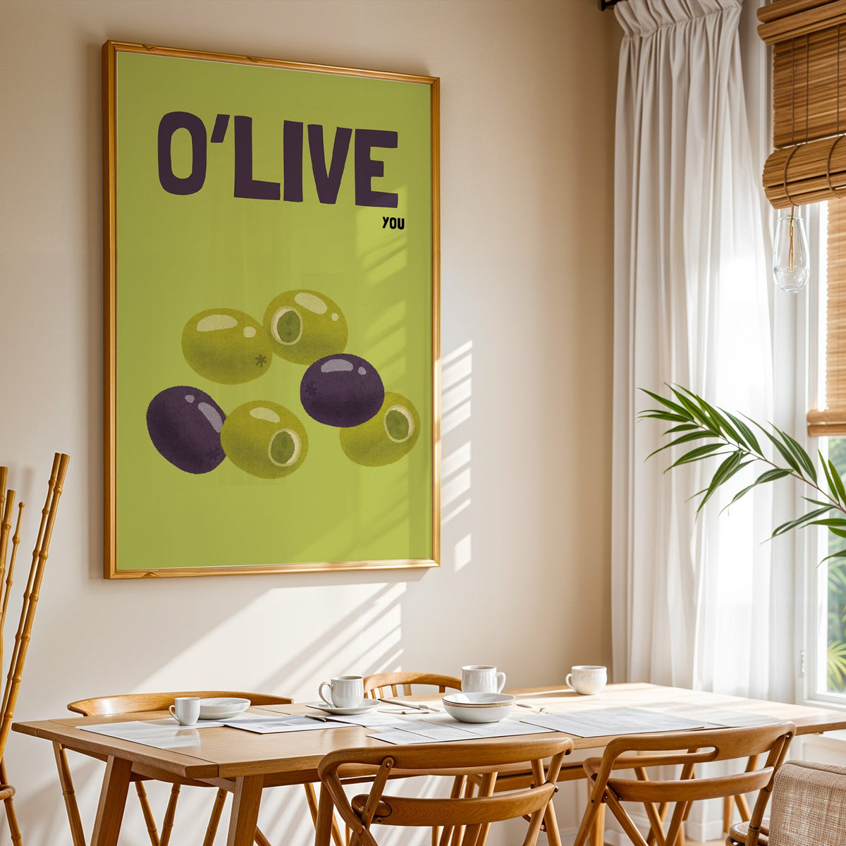 O Live You olives print shown in a gold frame above a breakfast table by a curtained window