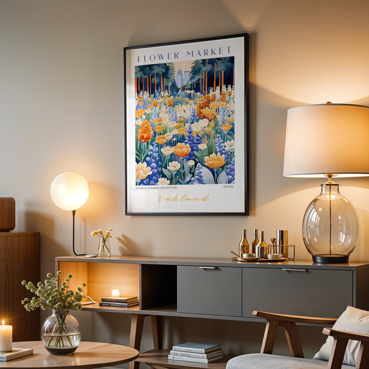 Oakland flower market print in a black frame above a grey media console with a glass table lamp