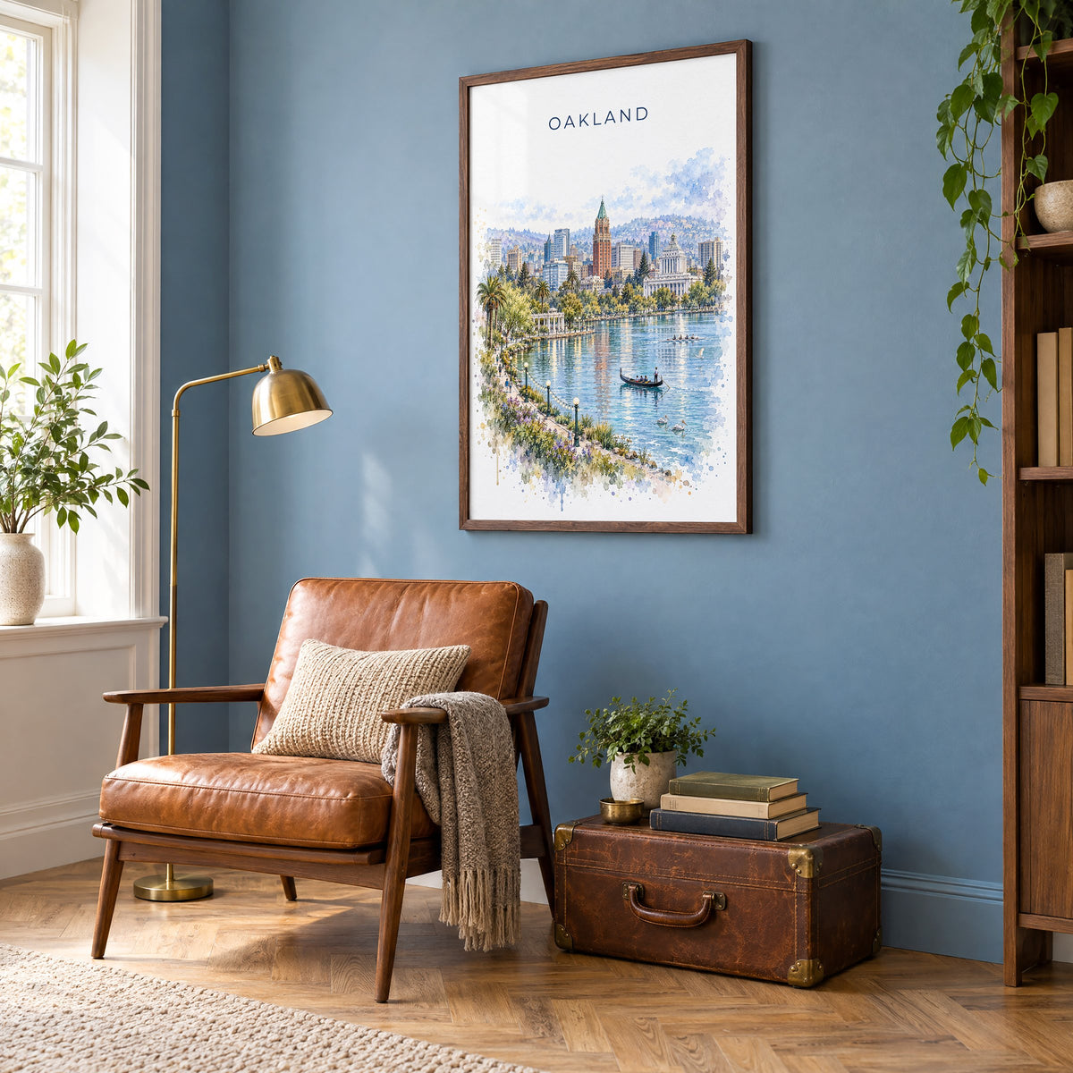 Oakland watercolor print in a walnut frame on a blue wall above a leather armchair in a reading nook