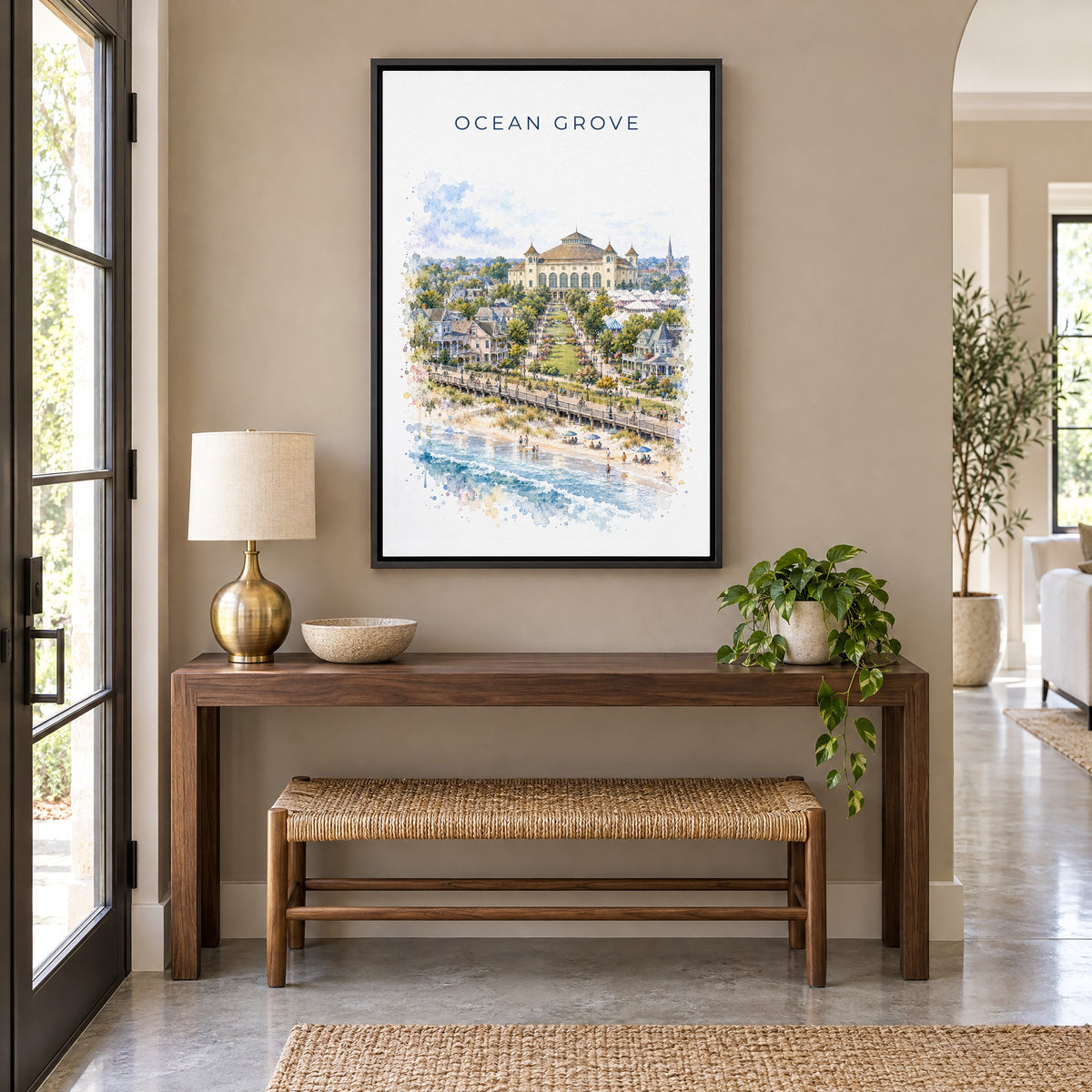 Ocean Grove, New Jersey watercolor print as a black floater canvas above a walnut console and woven bench in an entryway