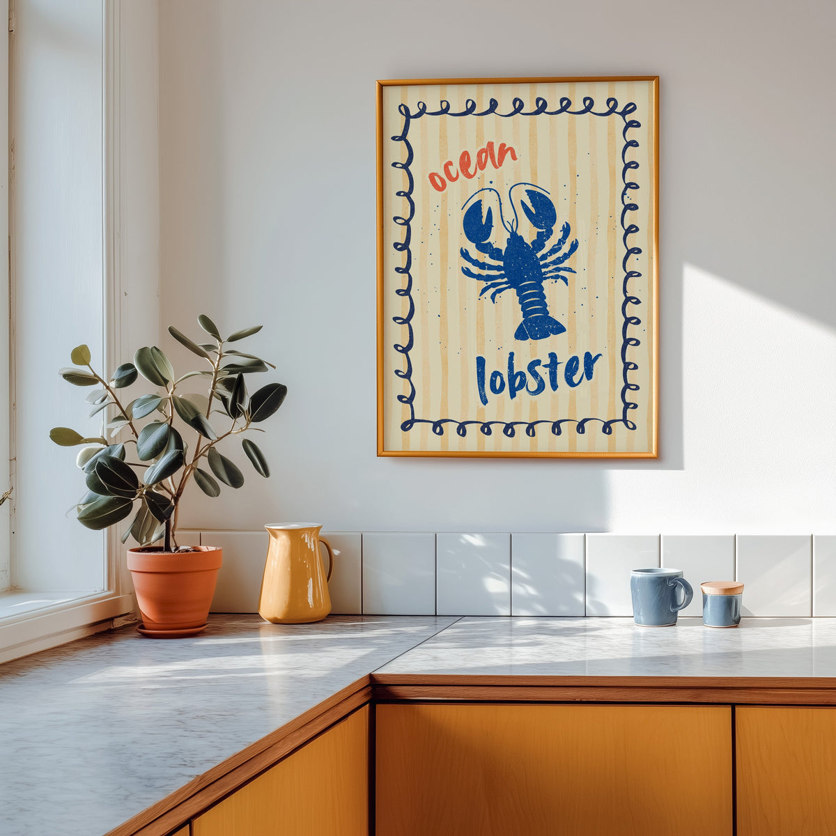 Blue lobster print shown in a gold frame above a marble counter with a yellow ceramic jug