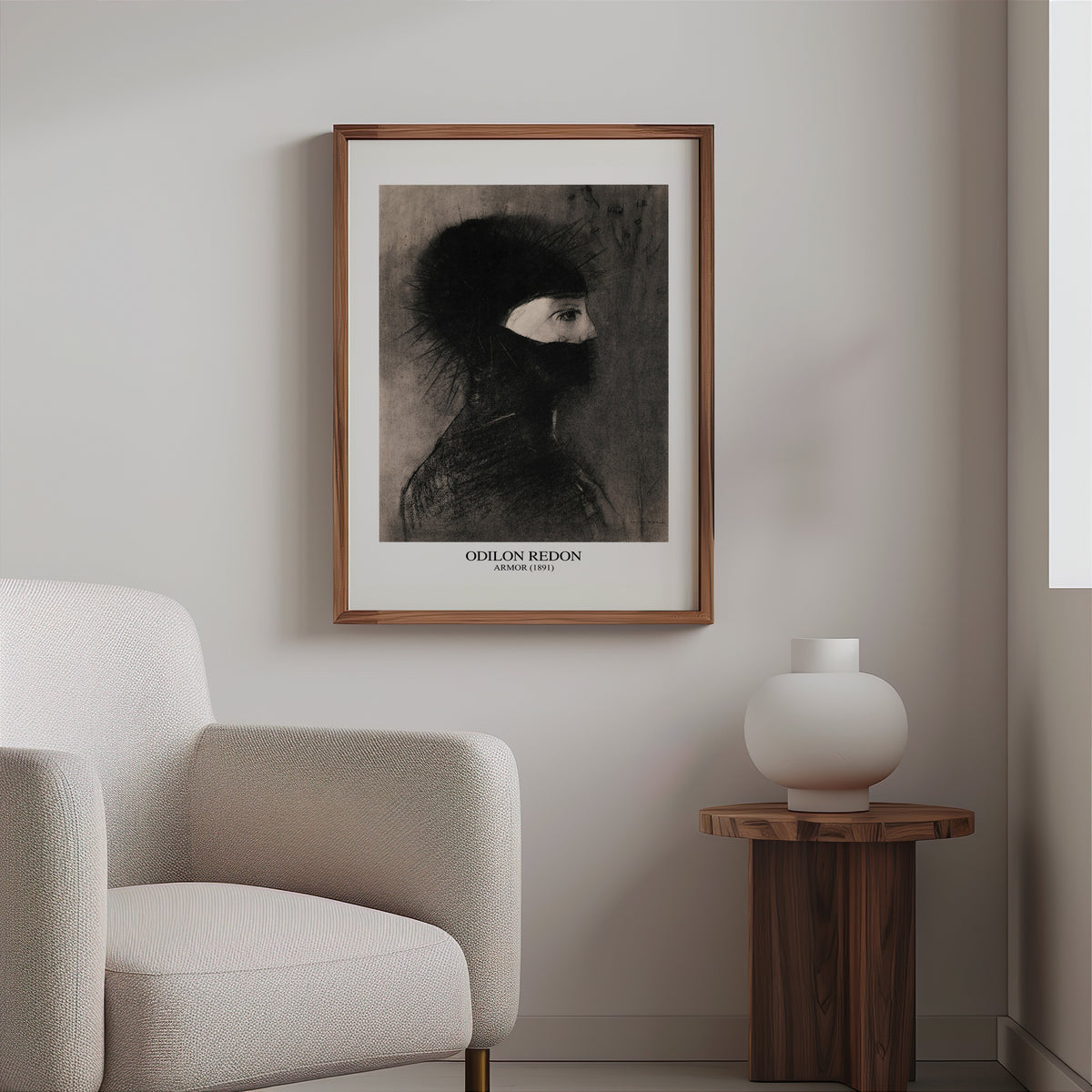 Dark symbolist drawing print in a slim walnut frame above a bouclé armchair
