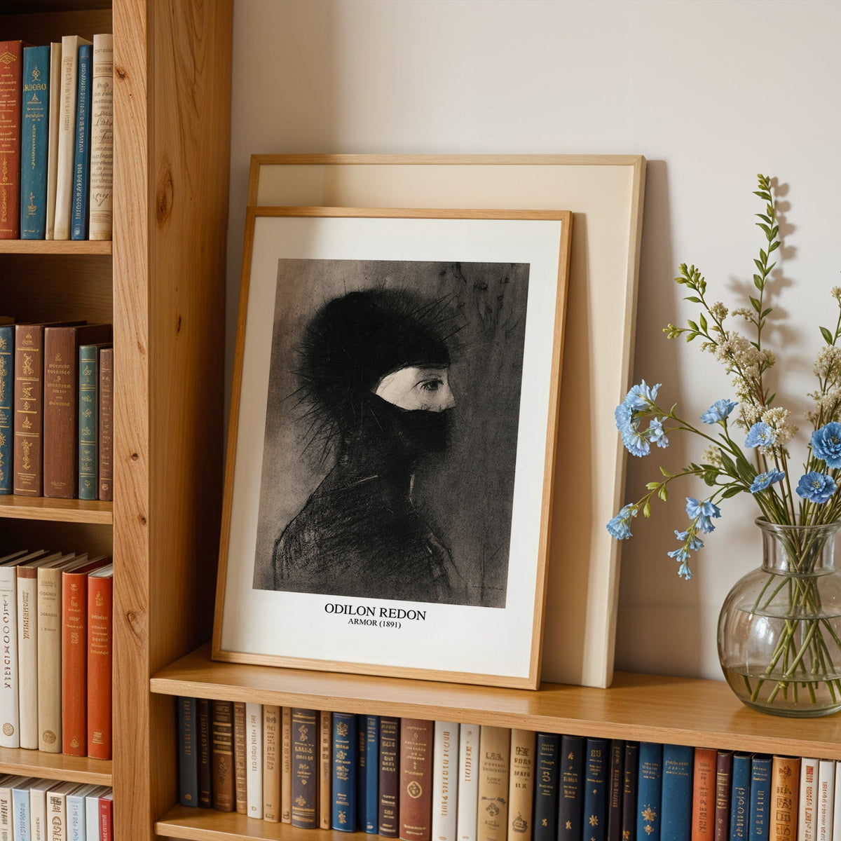 Helmeted profile drawing print in an oak frame leaning on a bookshelf beside flowers