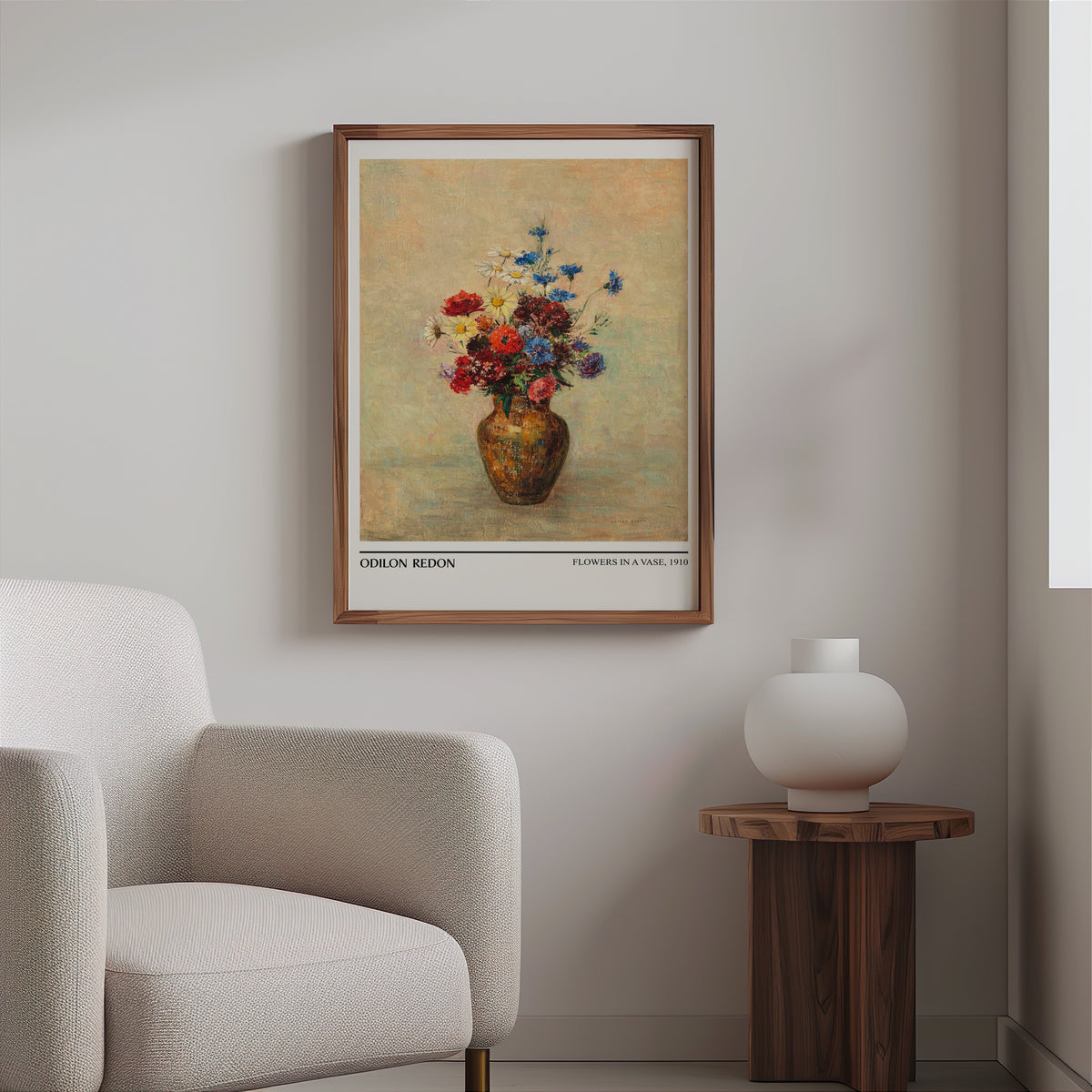 Wildflower bouquet painting print in a slim walnut frame above a bouclé armchair