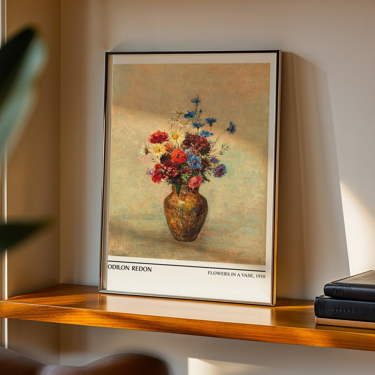 Redon bouquet print in a black frame on a walnut shelf in evening light