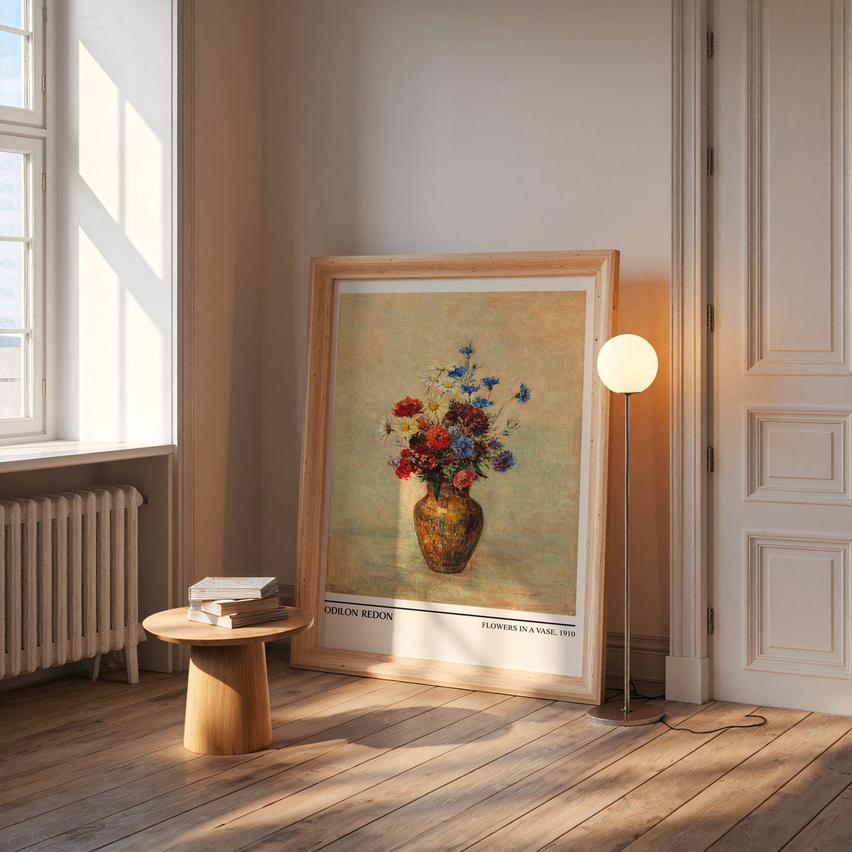 Flowers in a vase print in a wide pine frame leaning by a sunlit window