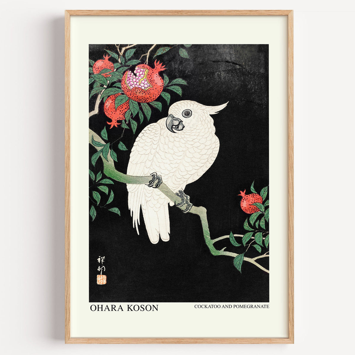 Ohara Koson Cockatoo and Pomegranate print in a light oak frame on a white wall