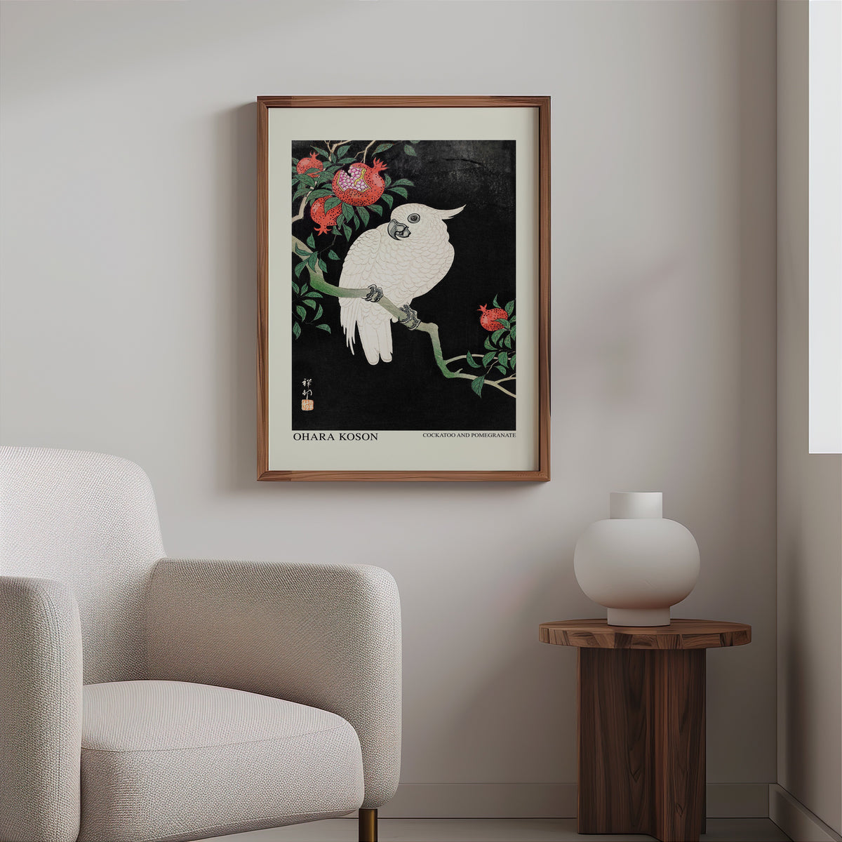 Koson cockatoo print in a slim walnut frame above a bouclé armchair
