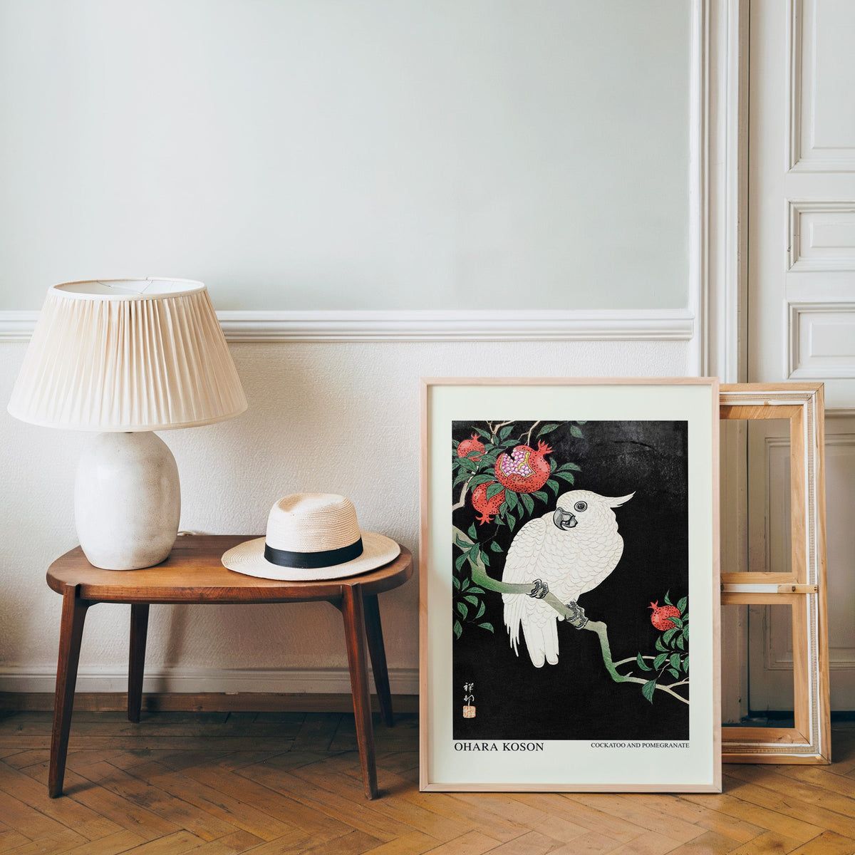 Japanese bird poster in a light wood frame leaning by a bench and panama hat