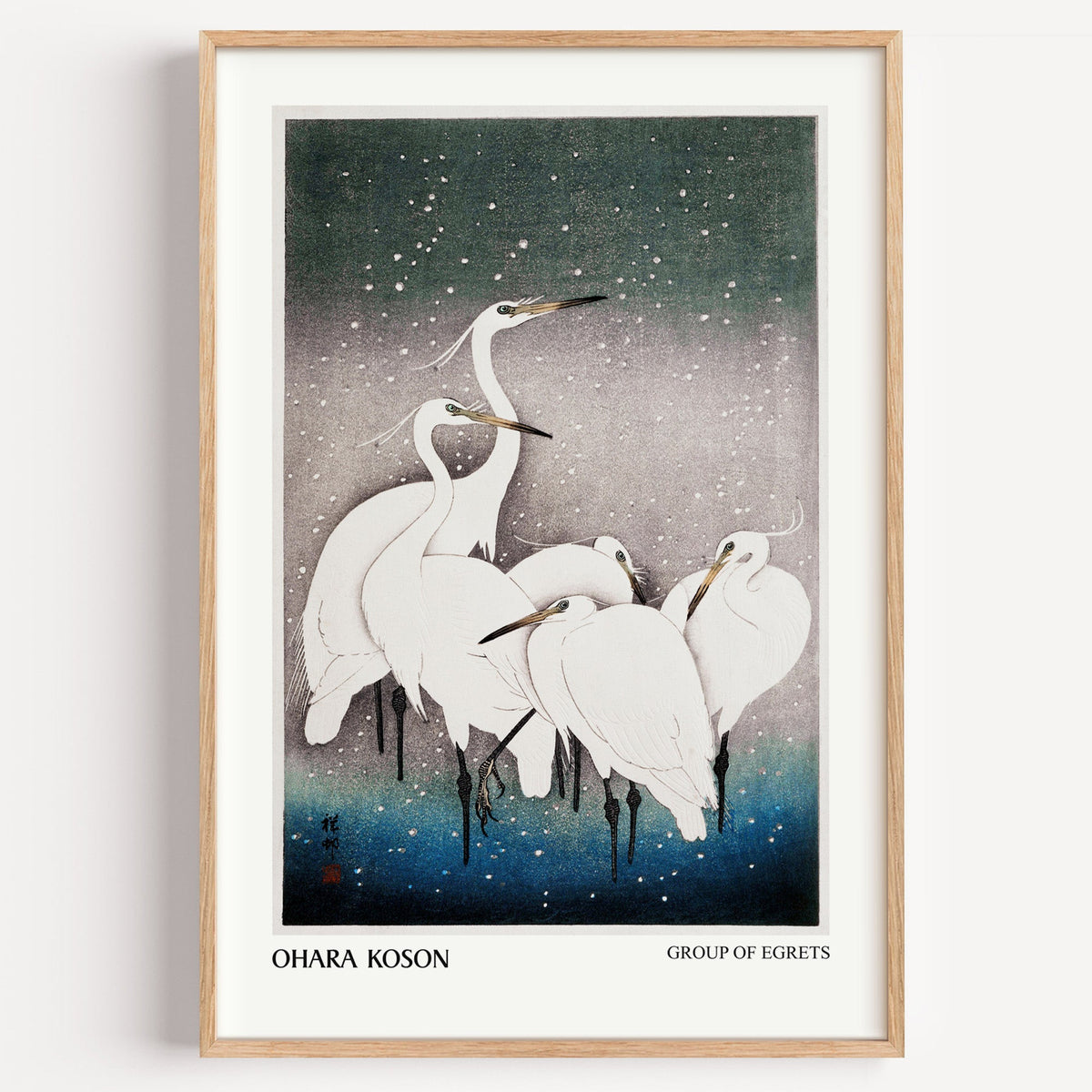Ohara Koson Group of Egrets print in a light oak frame on a plain white wall