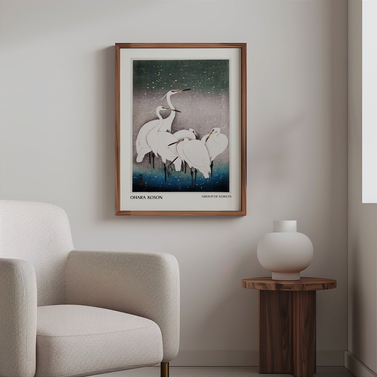 Koson egret print in a slim walnut frame above a bouclé armchair