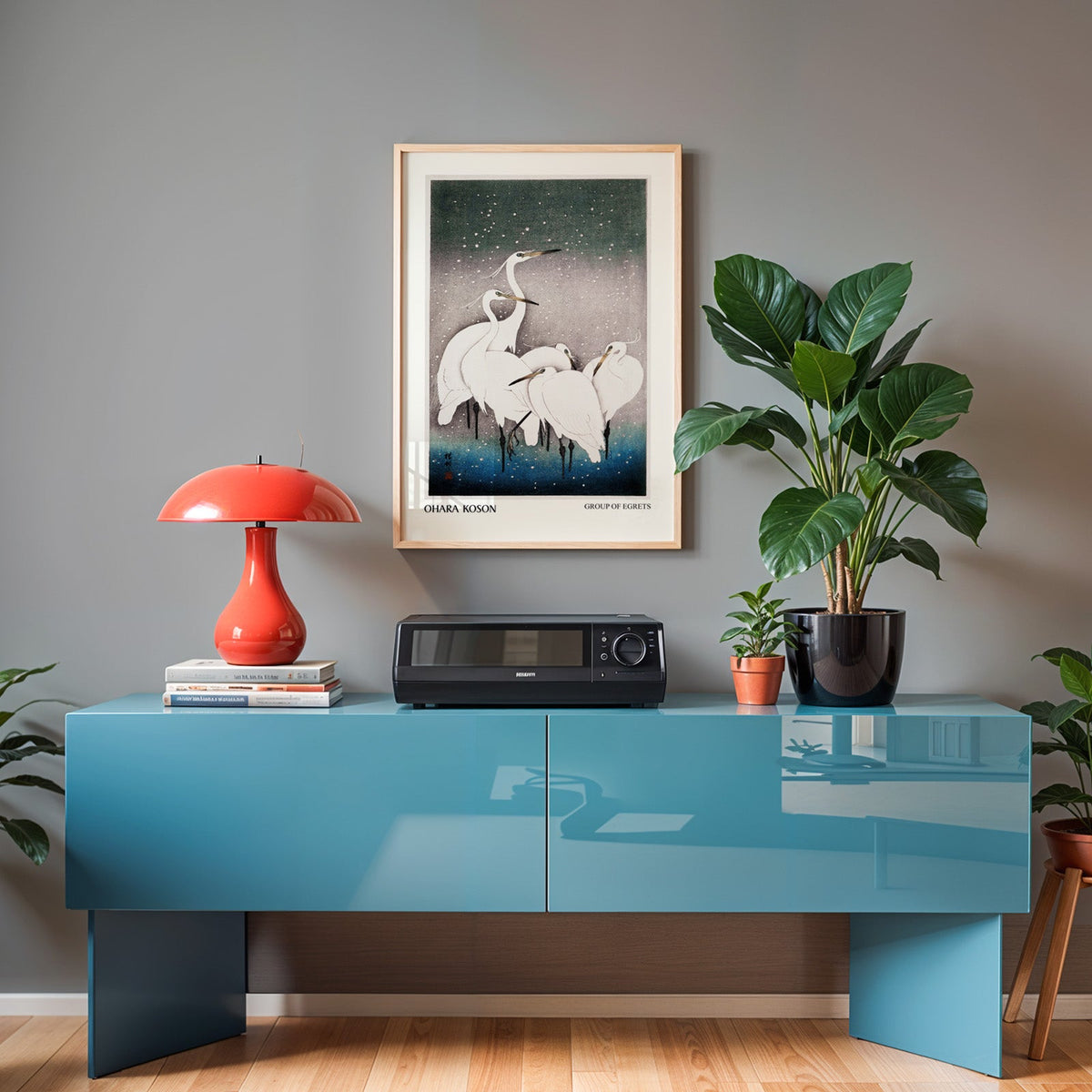 White heron woodblock print in an oak frame above a teal sideboard