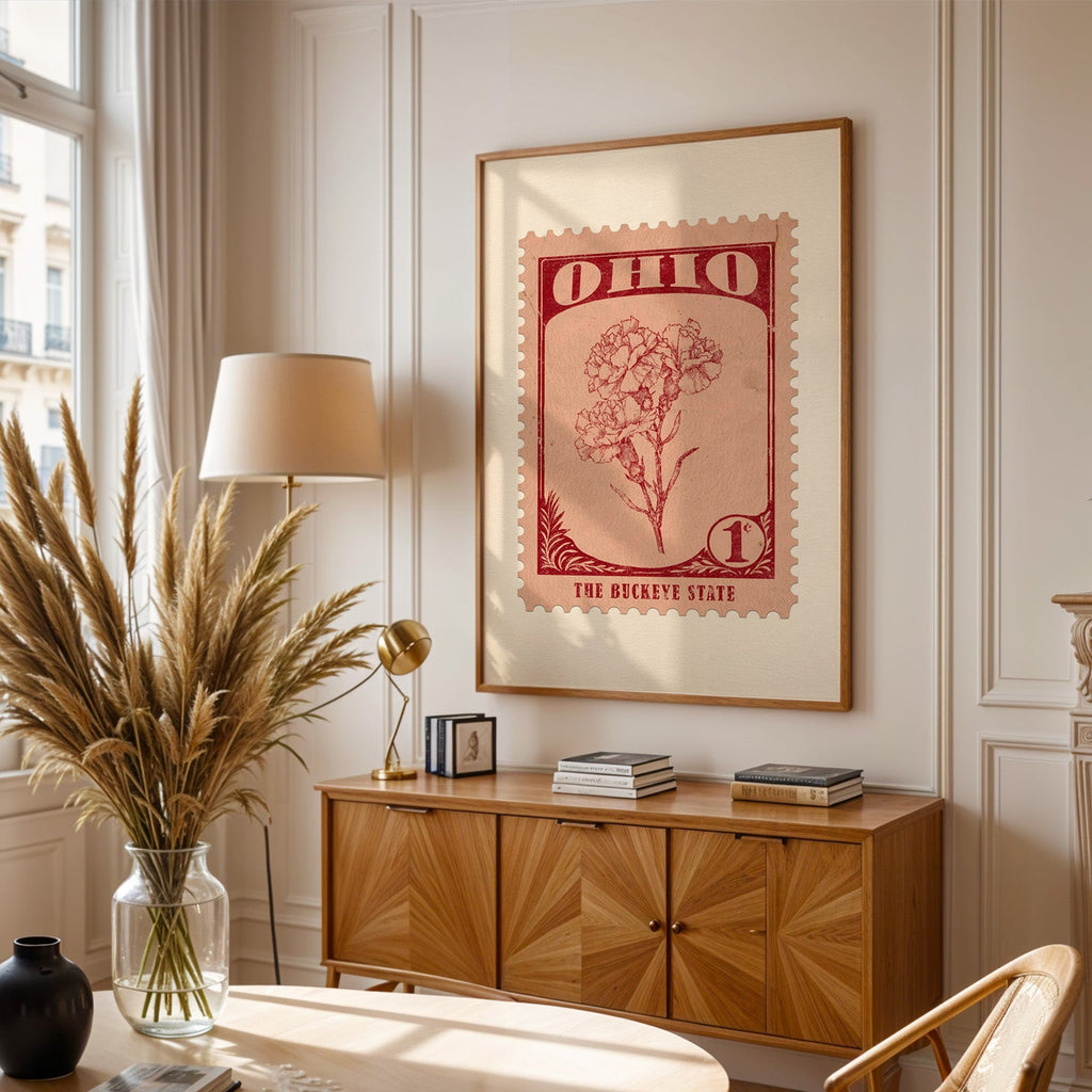 Ohio stamp print framed above a wooden sideboard, pampas grass in a glass vase and a floor lamp